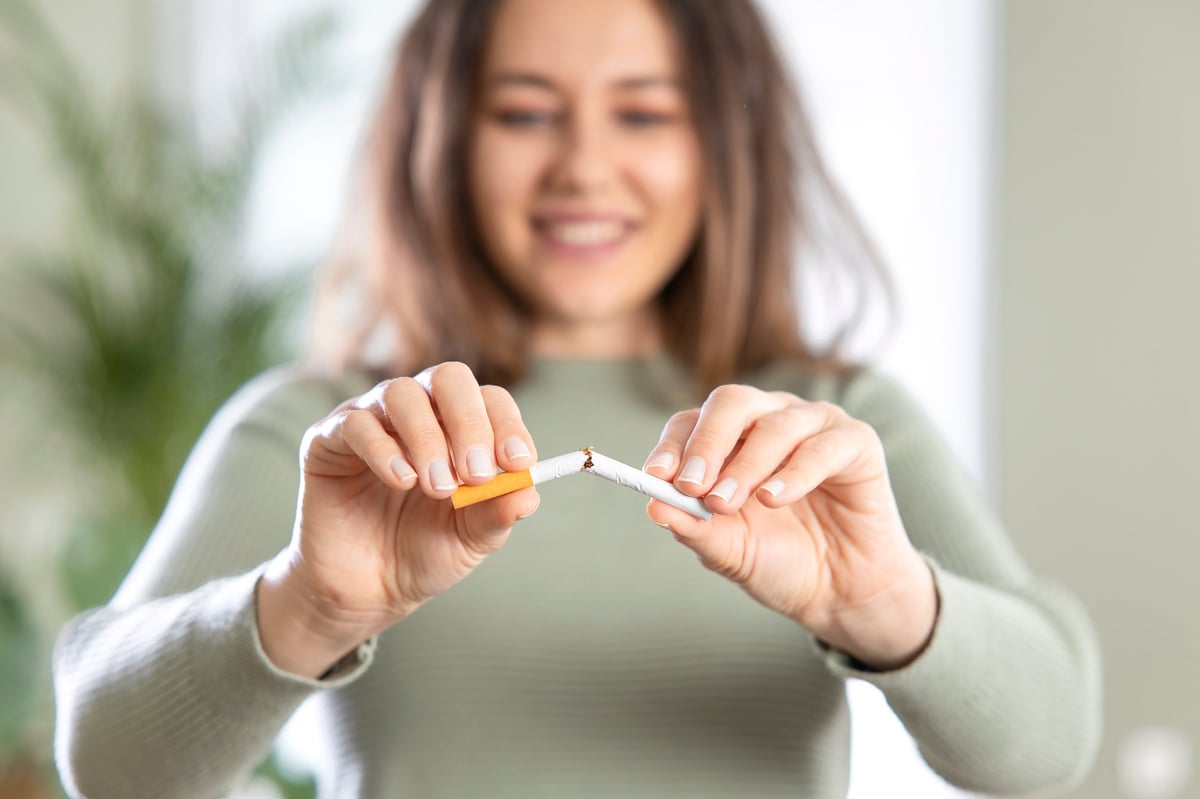 Persona rompiendo un cigarrillo, concepto de dejar de fumar