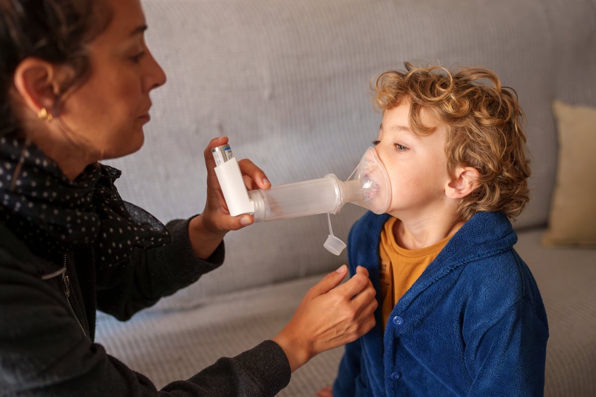 Persona usando un inhalador con espaciador.