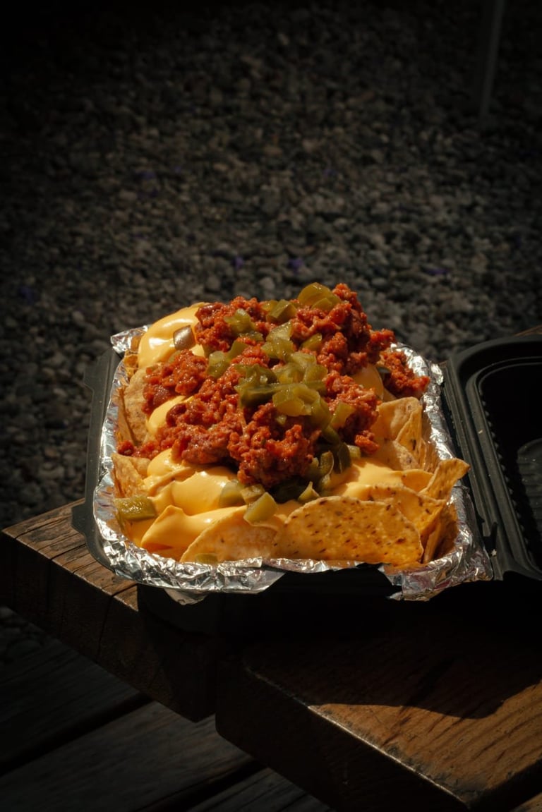 Loaded nachos with melted cheese, spiced meat, and jalapeños