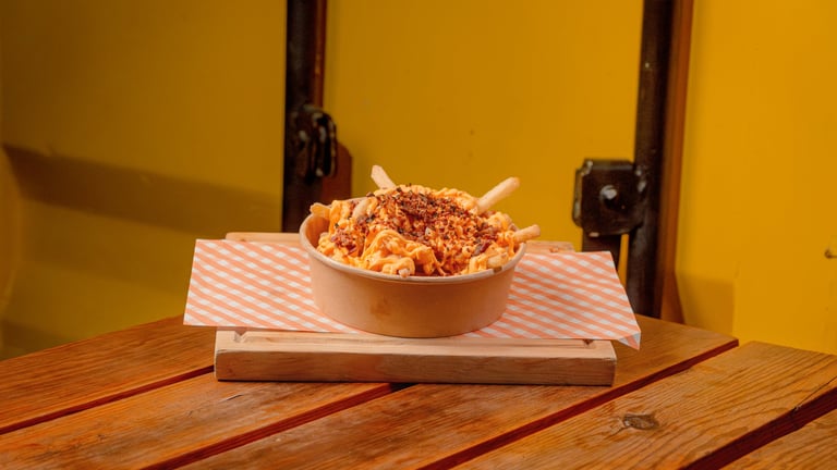 Papas con queso cheddar y tocino crujiente