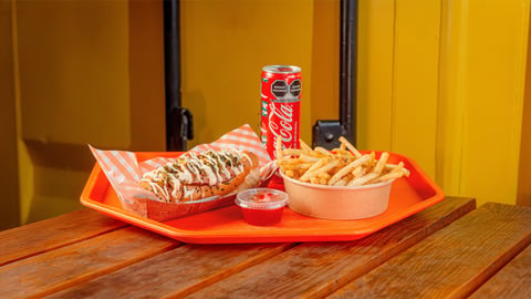 Fast food meal on orange tray with sandwich, fries, drink, and sauce cup
