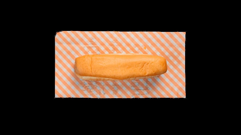 Fresh baguette on striped orange and white paper